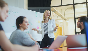 Lady presenting in front of a group of men