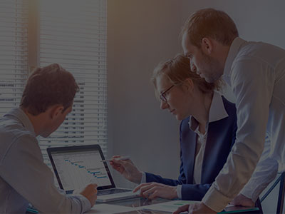 Executives gathering around laptop