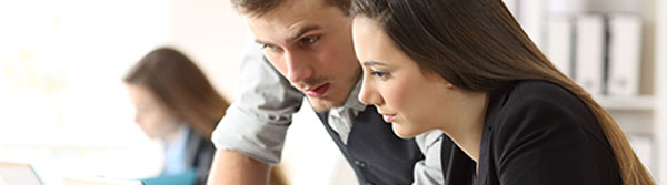 Man coaching a lady at her desk