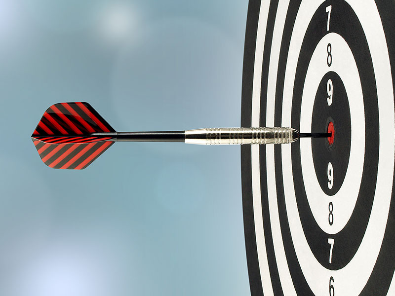 Dartboard with dart hitting a bullseye