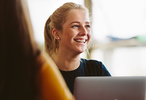 Lady smiling behind laptop