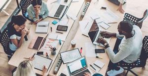 Multicultural employees working together at desk