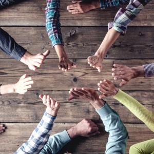 Team members high fiving across a table