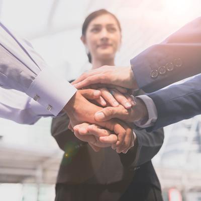 Lady in front of people placing hands together