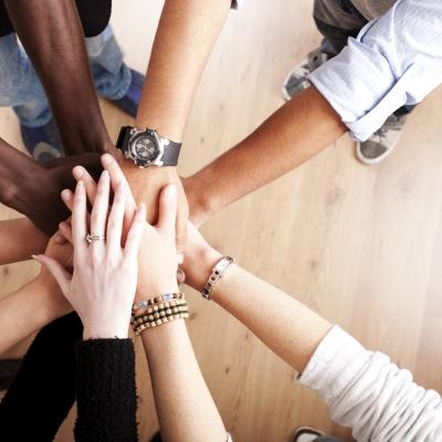 Standing in a circle placing hands together