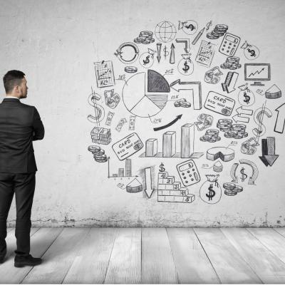 Man standing up with arms crossed looking at various business icons