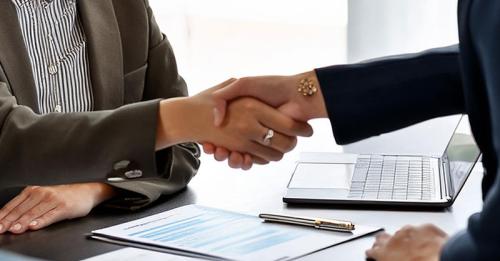 Closeup of HR manager shaking employee's hand