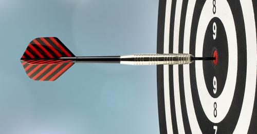 Dartboard with dart hitting a bullseye