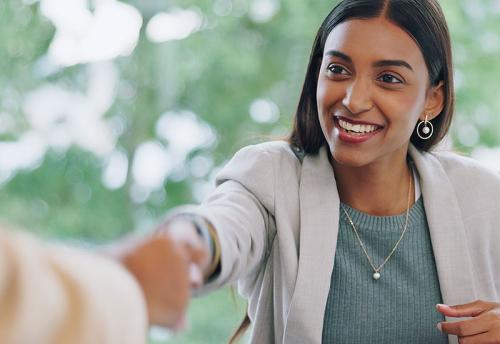 Young female Inidian HR Manager holding her hand out to employee