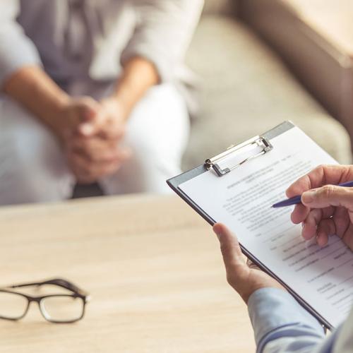 Recruiter interviewing candidate with notepad