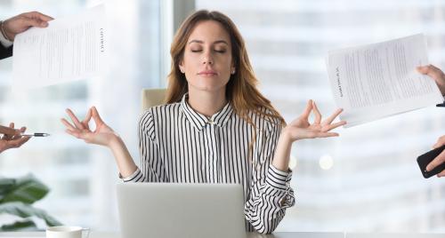 Lady doing balance gesture with hands behind computer