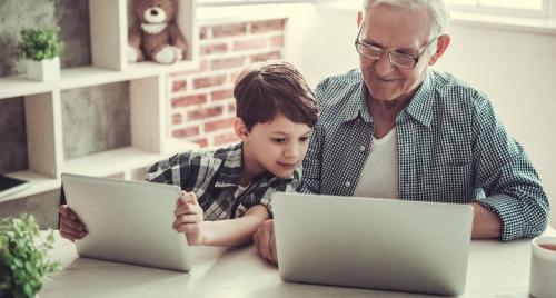 Old man on laptop with child