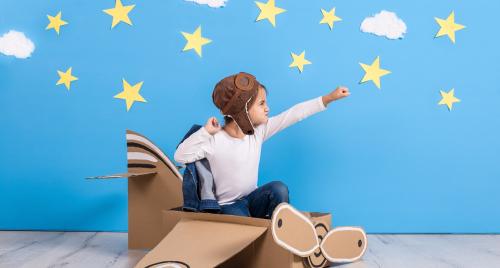 Boy in cardboard aeroplane playing