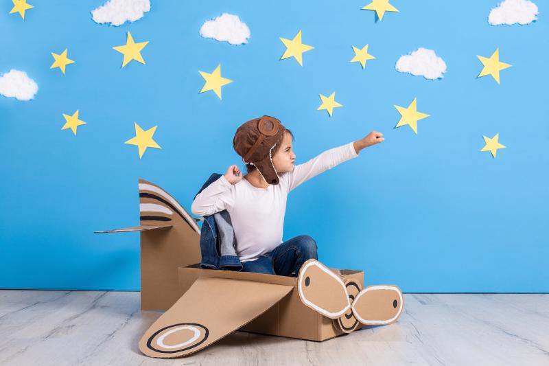 Boy in cardboard aeroplane playing